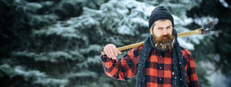 Photo for Hipster with beard on serious face with axe. Lumberjack brutal bearded man holds axe. Brutal lumberjack in winter. Lumberjack hipster in snowy forest - Royalty Free Image