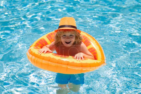 Foto de Niño pequeño en piscina con anillo de juguete inflable. Vacaciones de verano para niños. Nadar para niños en flotador. Playa mar y agua diversión - Imagen libre de derechos