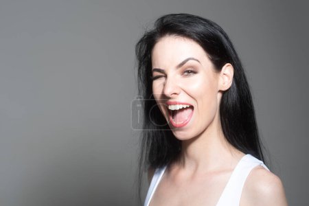 Photo for Confused beautiful blonde winks woman with questioning gesture. Girl shrugging shoulders, doubts - Royalty Free Image