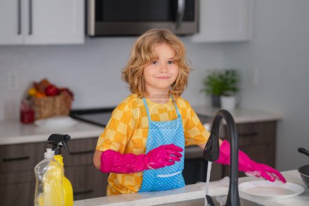 Photo for Child doing and wiping dishes in kitchen. Little kid cleaning at home. Child doing housework having fun. Cute child boy helping with housekeeping in kitchen, cleaning - Royalty Free Image