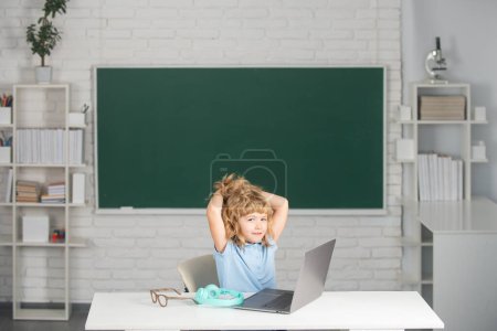 Photo for School pupil wearing headphones, learning online in class. Teacher tutor on laptop by video conference, watching lesson. Pupil rest and relaxing after school lesson - Royalty Free Image