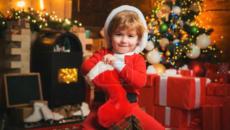 Photo for Child got gift in christmas sock. Concept of christmas stocking. Kid boy hold christmas gift - Royalty Free Image