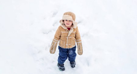 Foto de Banner de invierno. Retrato de niño en la nieve. Lindo niño en el helado parque de invierno. Feliz invierno para los niños. Nieve juego de niños. Niño jugando con la nieve en el parque de invierno nevado - Imagen libre de derechos