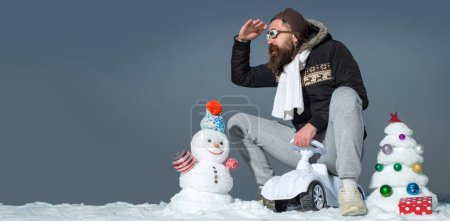 Téléchargez les photos : Homme fou d'hiver à vélo en plein air. Homme avec bonhomme de neige sur fond d'hiver extérieur. Bonhomme de neige pour bannière d'hiver - en image libre de droit