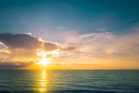 Foto de Puesta de sol en la playa tropical mar océano con nubes del amanecer. Banner para vacaciones de viaje. Paisaje cielo y reflejos rayos en el agua. Océano Pacífico. Crepúsculo, crepúsculo en el mar. Tranquilo, fondo dorado del cielo - Imagen libre de derechos