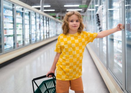 Photo for Child with shopping basket at grocery store. Healthy food for kids. Portrait of smiling little child with shopping bag at grocery store or supermarket - Royalty Free Image