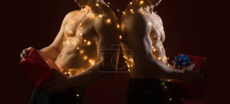 Photo for Sexy shirtless Santa. Sexy muscular men. Concept of the twins. Two twin brothers with bare naked body torso. Gay night club, banner for Christmas - Royalty Free Image
