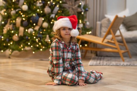 Téléchargez les photos : Enfant à la maison à Noël. Petit enfant célébrant Noël ou Nouvel An - en image libre de droit