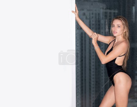 Photo for Fashion and sexy. Sensual woman posing on window with city skyscrapers view. Copy space, banner - Royalty Free Image