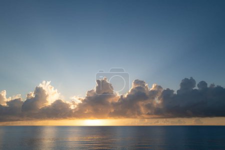 Sunset on sea background. Calm water ocean. Nature wallpaper with summer sea. Water sea texture. Calm sunrise on tropical sea