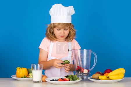 Photo for Portrait of chef child in cook hat. Cooking at home, kid boy preparing food from vegetable and fruits. Healthy eating - Royalty Free Image