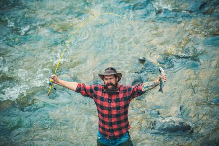 Photo for Fisherman fishing on a rever. Excited amazed fisher man in water catching trout fish, top view - Royalty Free Image