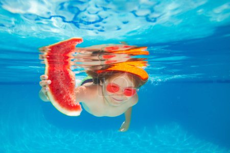 Téléchargez les photos : Jeune garçon nager et plonger sous l'eau, tenir pastèque. Portrait sous l'eau dans piscine. Enfant garçon plongeant dans une piscine - en image libre de droit