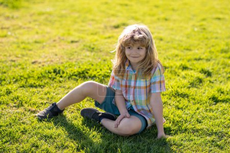 Photo for Summer kids outdoor portrait. Happy child enjoying on grass field and dreaming. Kids on green grass background. Kids on green grass background - Royalty Free Image