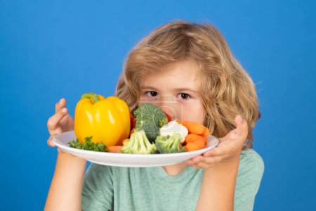 Photo for Funny child hold plate with vegetables . Healthy breakfast for kids. Fruits and vegetables for children. Healthy kids food - Royalty Free Image