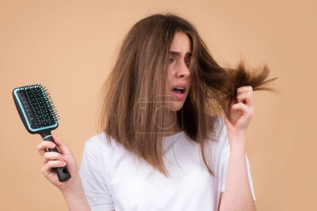 Foto de Chica triste mirando el cabello dañado, el problema de la pérdida de cabello. Espacio aislado, copia - Imagen libre de derechos