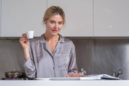 Foto de Las mujeres beben café, leen libros o revistas en una cocina. Sexy ama de casa en la mañana - Imagen libre de derechos