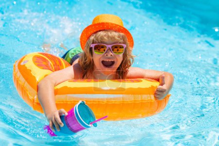Photo for Active healthy lifestyle, swim water sport activity on summer vacation with child. Summer kids Cocktail. Happy little boy with colorful inflatable ring in outdoor swimming pool on hot summer day - Royalty Free Image