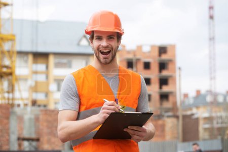 Foto de Retrato de constructor de construcción. Obrero de la construcción con ropa de trabajo y casco de construcción - Imagen libre de derechos
