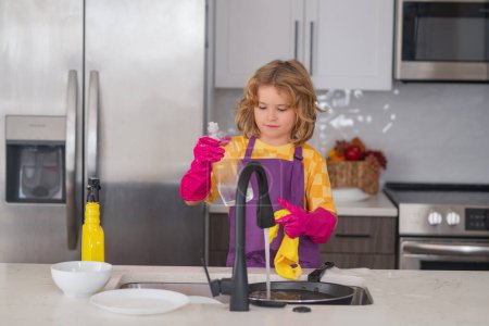 Photo for Cleaning house. Portrait of child cleaning in the kithen at home, concept growth, development, family relationships. Child housekeeper washing the dishes on soapy water - Royalty Free Image