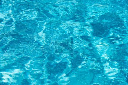Téléchargez les photos : Eau déchirée dans la piscine. Surface de la piscine bleue, fond d'eau - en image libre de droit