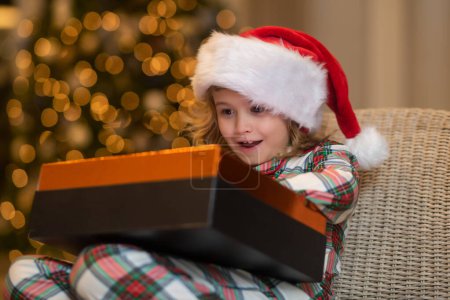 Téléchargez les photos : Joyeux Noël. Joyeux enfant près du sapin de Noël. Noël et bonnes vacances à la maison. Joyeux garçon mignon cadeaux d'ouverture. Des enfants près d'un arbre le matin. Cadeaux de Noël dans la chambre - en image libre de droit