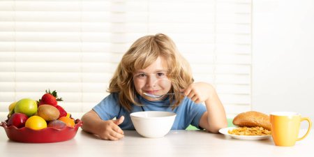 Photo for Kid preteen boy 7, 8, 9 years old eating healthy food vegetables. Breakfast with milk, fruits and vegetables. Child eating during lunch or dinner at home - Royalty Free Image