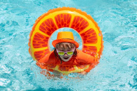 Téléchargez les photos : Jeu d'enfants dans la piscine en journée d'été. Enfants jouant dans la piscine. Vacances d'été et concept de vacances - en image libre de droit