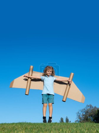 Photo for Little child plays astronaut or pilot. Child on the background of blue sky. Kids with paper wings jetpack dreams. Children imagines dreams of flying. Funny kid with toy jet pack. Success, imagination - Royalty Free Image