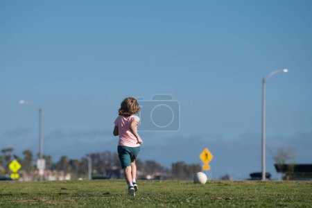Foto de Niño jugador de fútbol pateando fútbol en el campo de deportes. Niños activos. fútbol infantil fútbol - Imagen libre de derechos