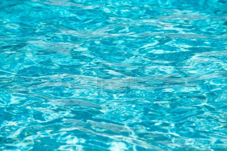 Téléchargez les photos : Fond d'eau bleue dans la piscine avec reflet de soleil, vague d'eau ondulée dans la piscine. Fond d'eau clair - en image libre de droit