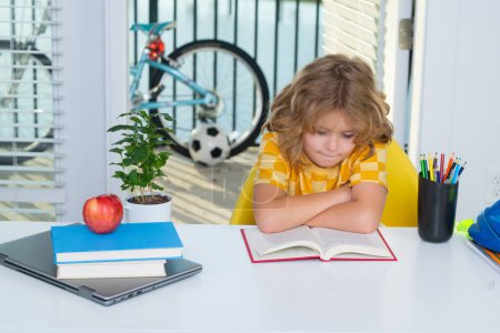 Photo for School kid reading book. School child studying in classroom at elementary school. Kid studying on lesson in class at elementary school - Royalty Free Image