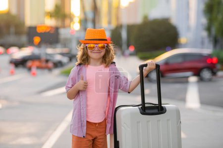 Foto de Kid with travel bag ready to travelling on his vacation. Travel concept - Imagen libre de derechos