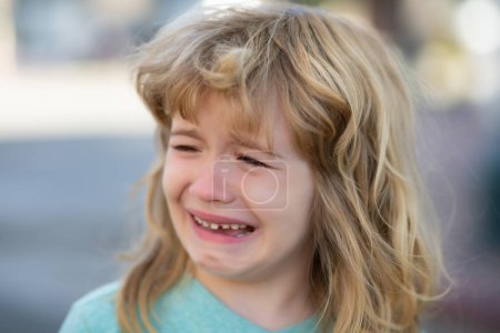 Foto de Portrait of crying kid with tears weeping emotion, hurt in pain. Tear drops on cheek - Imagen libre de derechos