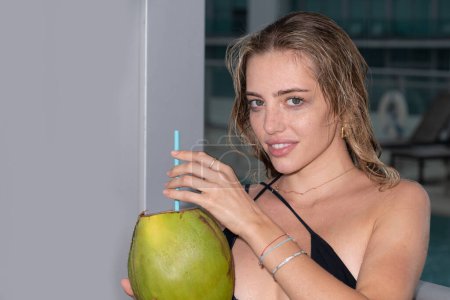 Téléchargez les photos : Close up portrait of young woman with coconut. Fashion model girl during a tropical vacation - en image libre de droit
