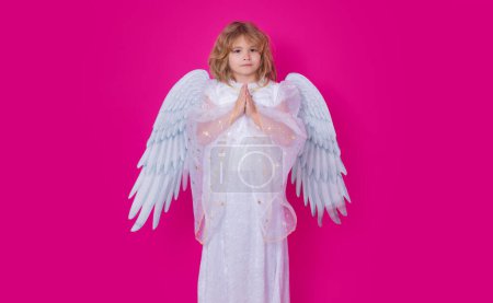 Photo for Angel prayer. Kid with angel wings with prayer hands, hope and pray concept. Studio portrait of angel child on studio color isolated background with copy space - Royalty Free Image