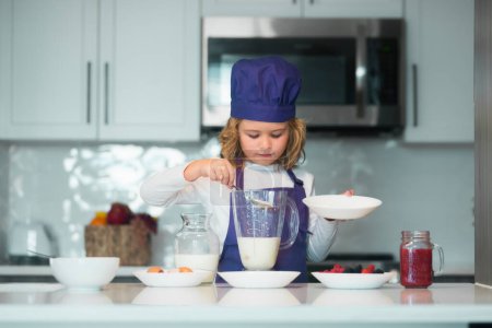 Photo for Chef kid preparing tasty food at kitchen. Kid making tasty delicious. little boy in chef hat and an apron cooking in the kitchen - Royalty Free Image