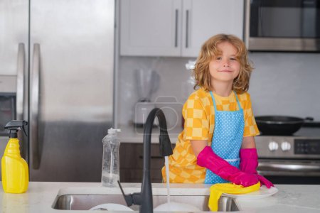 Téléchargez les photos : Cleaning at home. Child washing and wiping dishes in kitchen. American kid learning domestic chores at home. Kid cleaning to help parents with housework routine. Housekeeping children concept - en image libre de droit