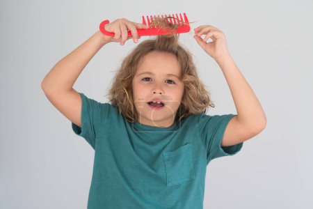 Photo for Kids hair. Funny child with curly blonde hair holding comb hairbrush for combing. Kid hair care. Kids hair care concept - Royalty Free Image