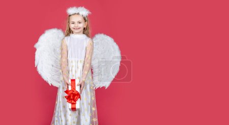 Photo for Angel child banner, isolated studio background. Angel child from heaven gives you gift. Cute toddler girl in white wings as Cupid. Horizontal banner for website header, copy space - Royalty Free Image