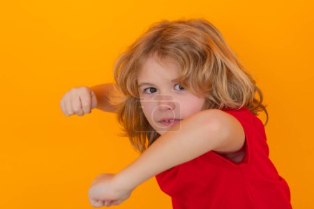 Photo for Angry child with fist gesture fight, hit on studio isolated background. Kid boy with mad expression handed punch. Bad kids behavior. Fury boy - Royalty Free Image