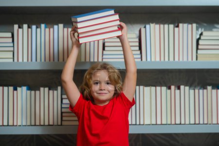 Photo for Excited school kid hold stack of books. Little student read book. Little student on school library. Child reading book at school. Nerd pupil studying at school - Royalty Free Image