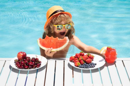 Téléchargez les photos : Healthy food. Outdoor leisure activity with kids by swimming pool. Summertime. Child eating fruits near swimming pool during summer holidays. Kids eat fruit. Healthy fruits for children - en image libre de droit