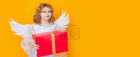 Foto de Cute blonde kid angel with gift box present. Valentines day. Panoramic banner wide poster horizontal header - Imagen libre de derechos