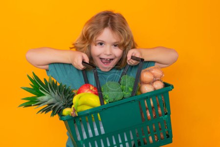 Foto de Grocery shop. Kid with shopping basket. Child at shopping. Little kid with shopping cart. Supermarket and grocery shop. Shopping, discount, sale concept - Imagen libre de derechos