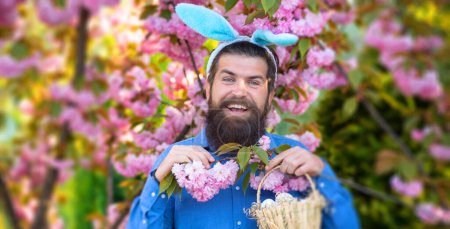 Photo for Man preparation for Easter. Bearded man with easter eggs on sprig garden. Easter hunt. Holidays. Easter banner, mockup copy space, poster flyer header for website template - Royalty Free Image