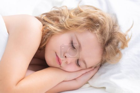 Téléchargez les photos : Kid sleeping in cozy white bed. Child sleeping on bed. Bedtime, kids sleeps. Kid asleep on pillow, having healthy sleep - en image libre de droit