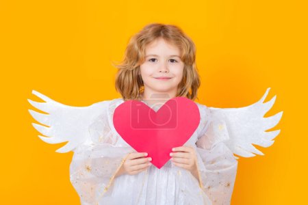 Foto de Angel with heart. Valentines day. Little cupid angel child with wings. Studio portrait of angelic kid - Imagen libre de derechos