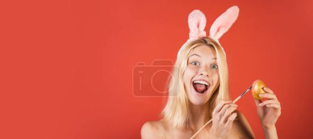 Foto de Easter banner, mockup copy space, poster flyer header for website template. Happy young woman in a rabbit costume with Easter eggs. Surprise woman - Imagen libre de derechos