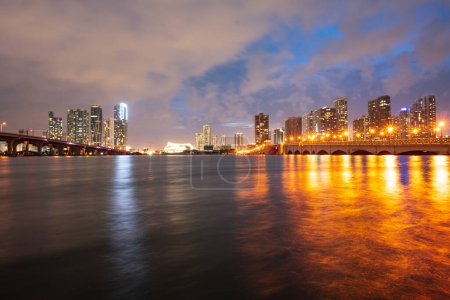 Foto de Miami city skyline panorama at night skyscrapers and bridge over sea with reflection. - Imagen libre de derechos